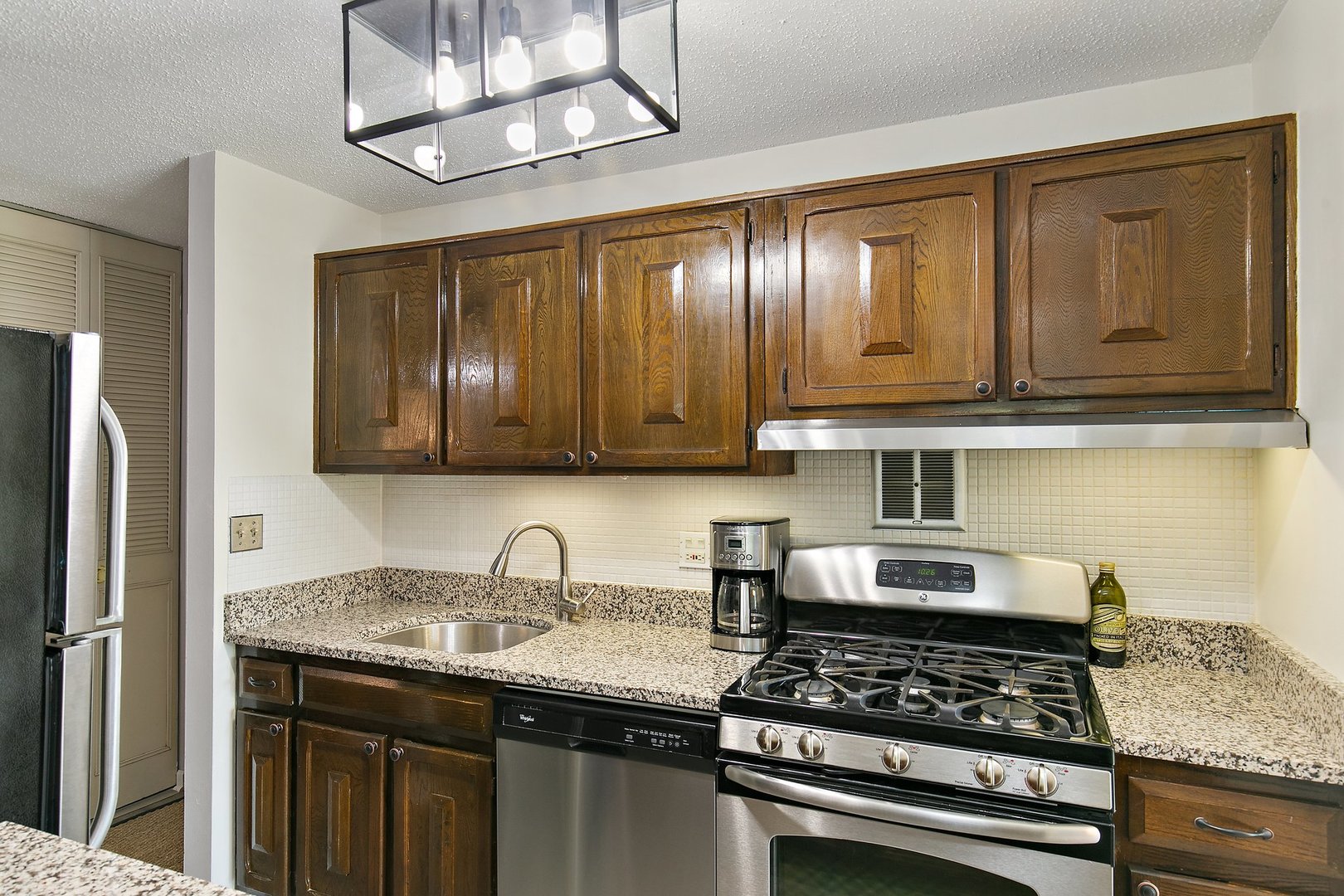 1207 South Old Wilke Road, Unit 409 Rolling Meadows, IL 60005 - Photo 4 of 26 a kitchen with granite countertop stainless steel appliances and wooden cabinets