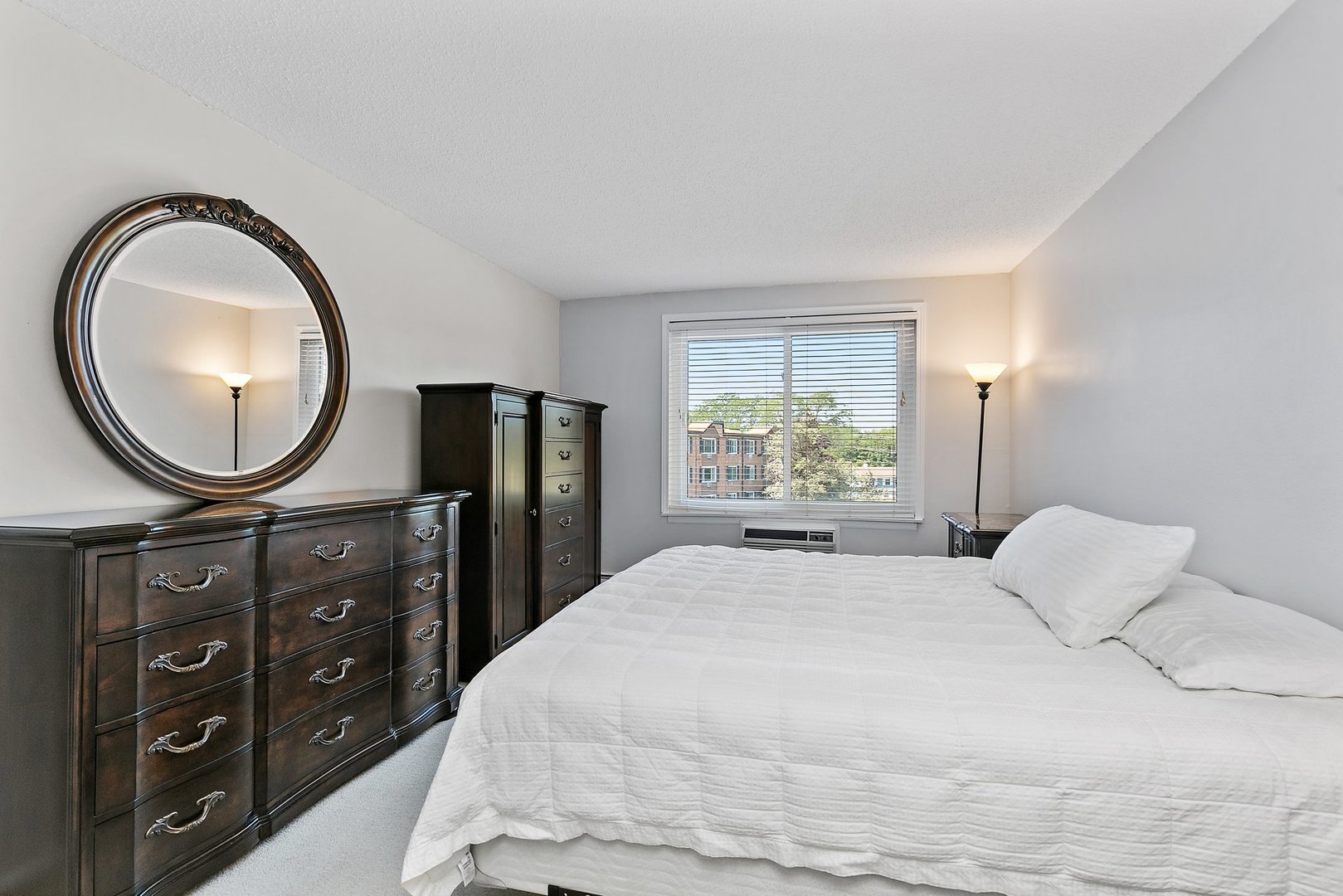 1207 South Old Wilke Road, Unit 409 Rolling Meadows, IL 60005 - Photo 8 of 26 a bedroom with a bed a mirror on dresser and a window