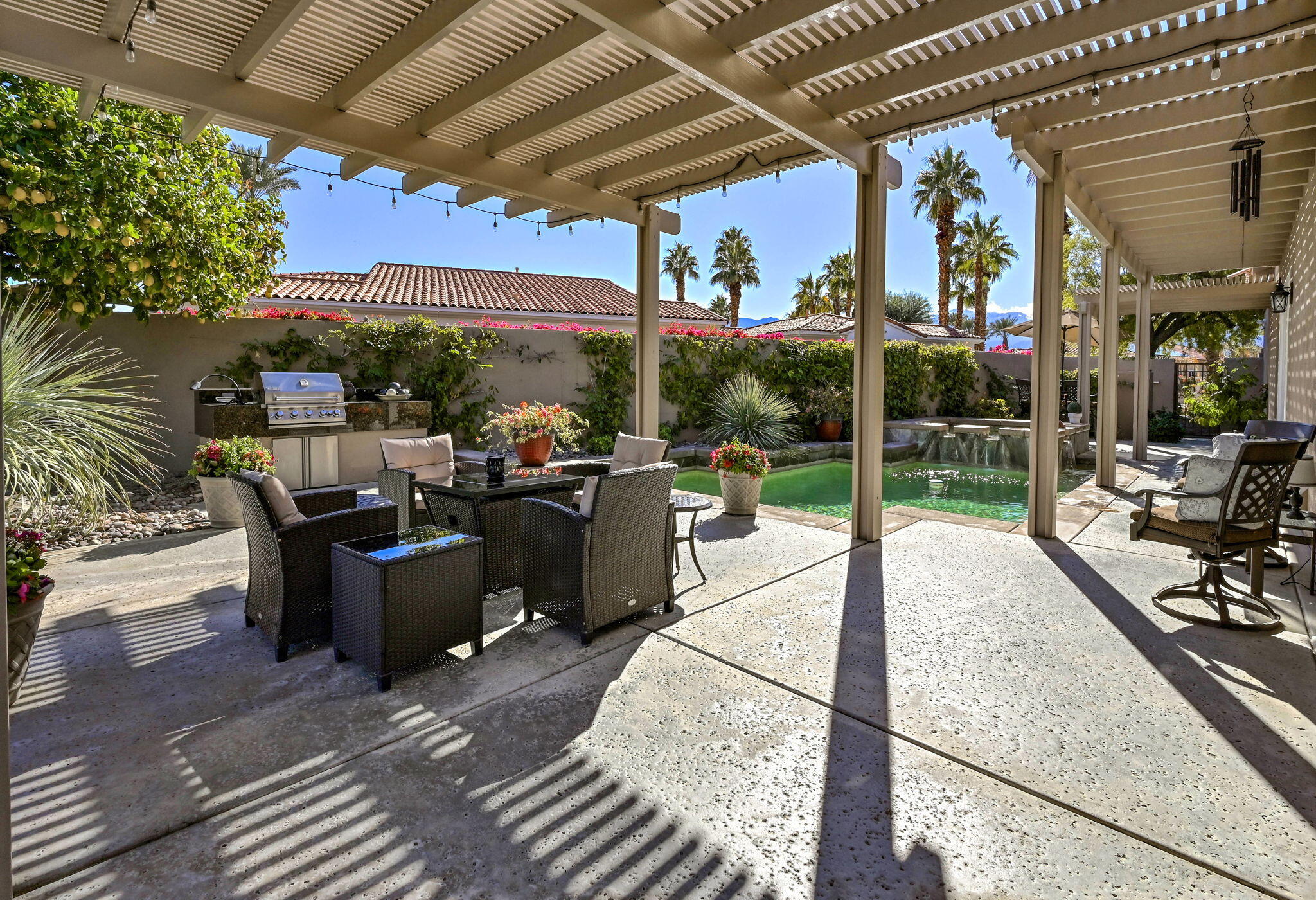 328 Tomahawk Drive Palm Desert, CA 92211 - Photo 32 of 56 a view of a patio with table and chairs potted plants with floor to ceiling window