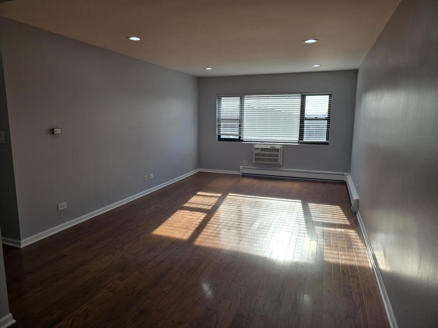 6400 North Ridge Boulevard, Unit 404 Chicago, IL 60626 - Photo 4 of 16 an empty room with wooden floor and windows