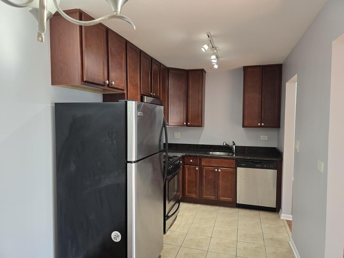6400 North Ridge Boulevard, Unit 404 Chicago, IL 60626 - Photo 8 of 16 a kitchen with stainless steel appliances granite countertop a refrigerator and a sink