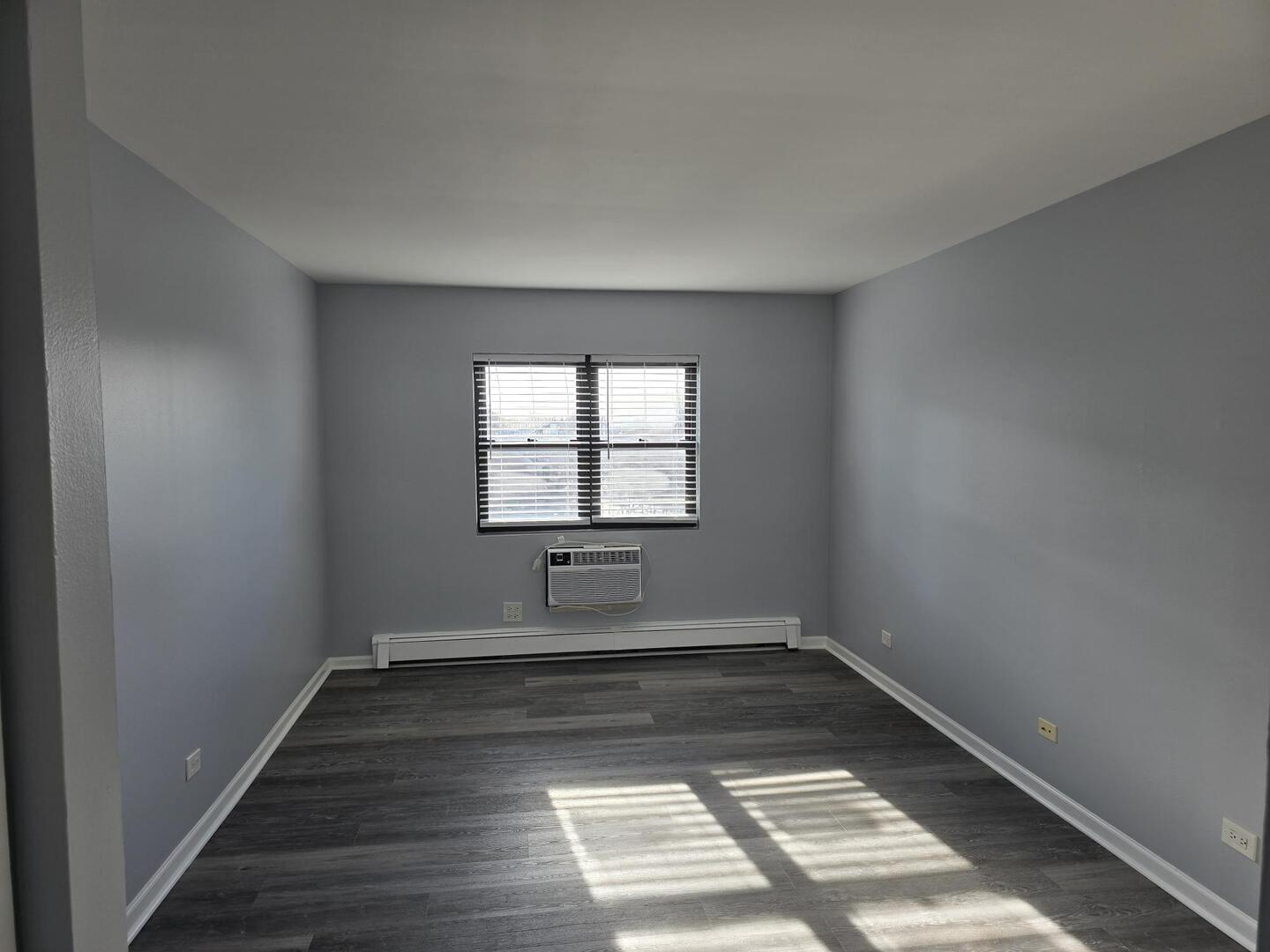 6400 North Ridge Boulevard, Unit 404 Chicago, IL 60626 - Photo 9 of 16 wooden floor in an empty room with a window