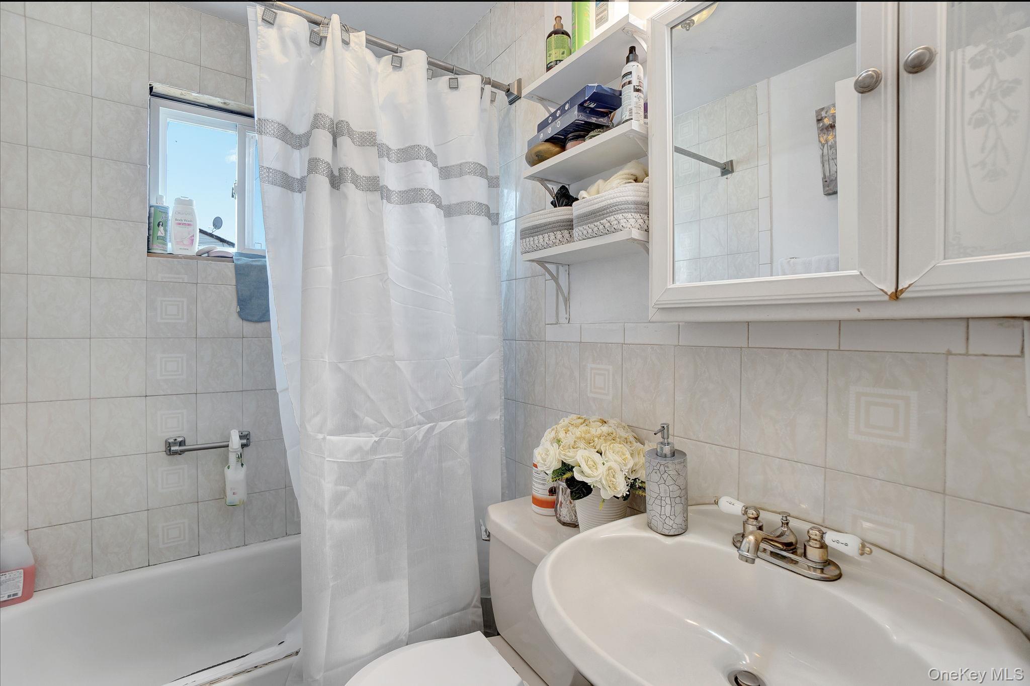 91 Cedar Road Amityville, NY 11701 - Photo 14 of 30 a bathroom with a sink toilet and shower