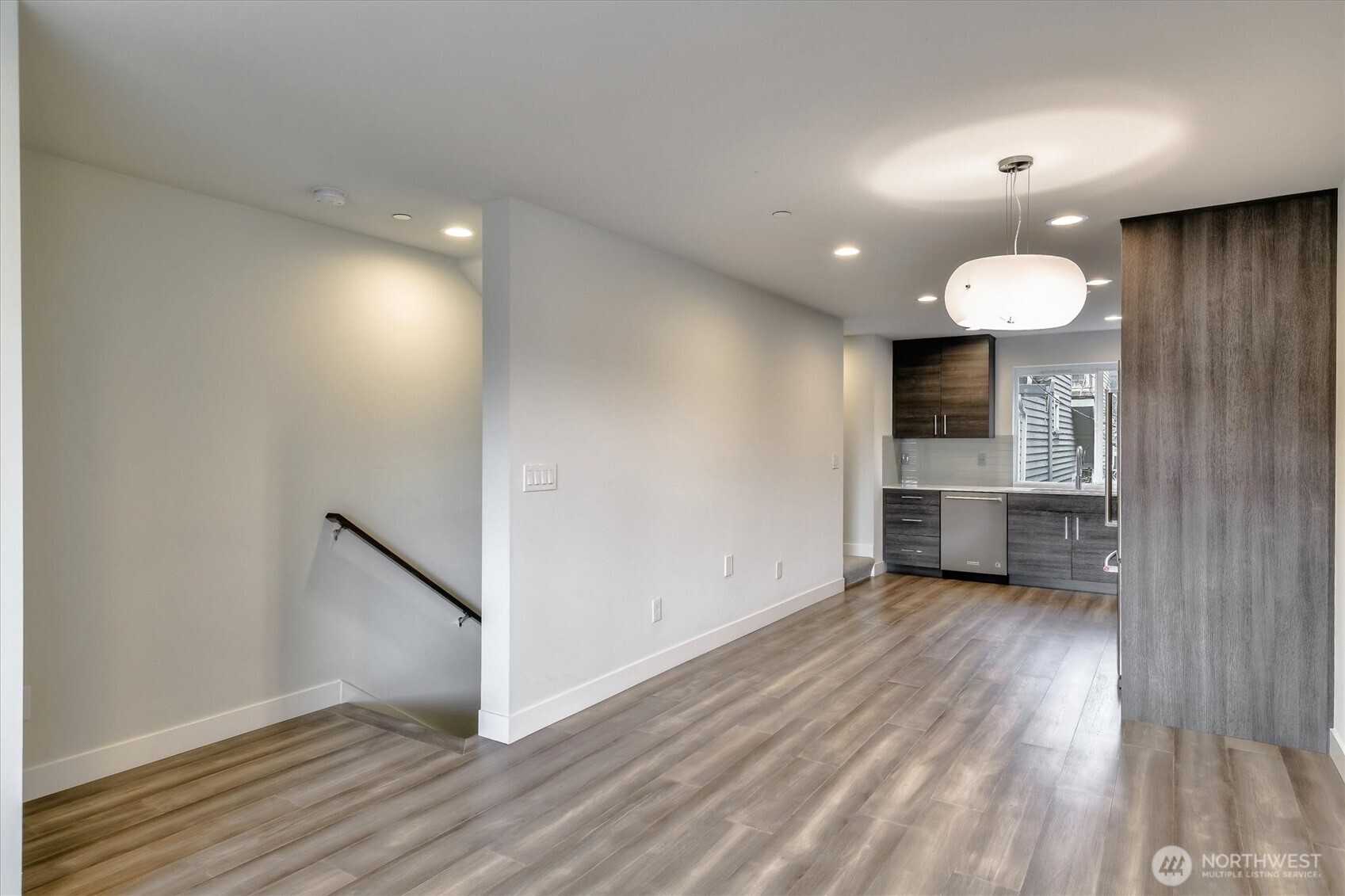 1919 24th Avenue South, Unit D Seattle, WA 98144 - Photo 8 of 35 a view of a room with wooden floor staircase and a kitchen