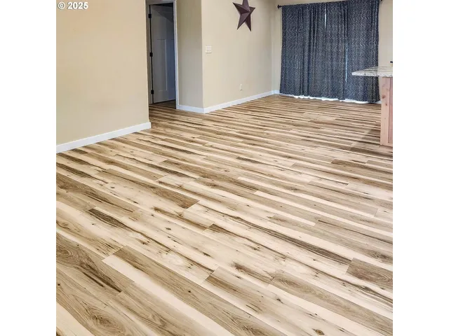 a view of a bedroom with wooden floor