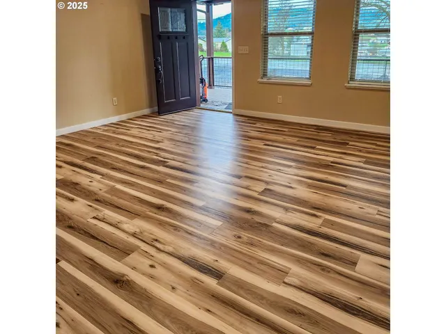 a view of a room with wooden floor and windows