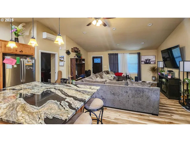 a living room with stainless steel appliances kitchen island granite countertop furniture and a kitchen view