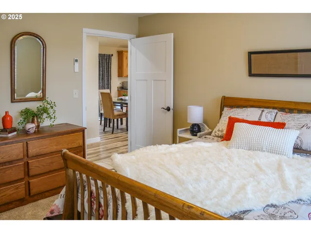 a bedroom with a bed and a dresser with mirror