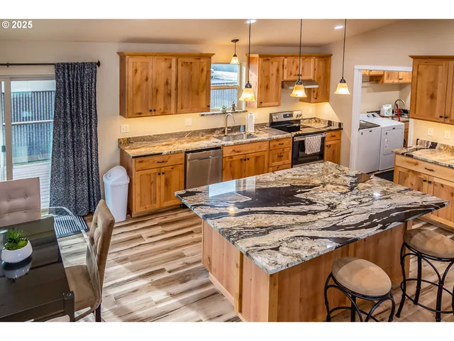 a kitchen with stainless steel appliances granite countertop a stove a sink and a refrigerator