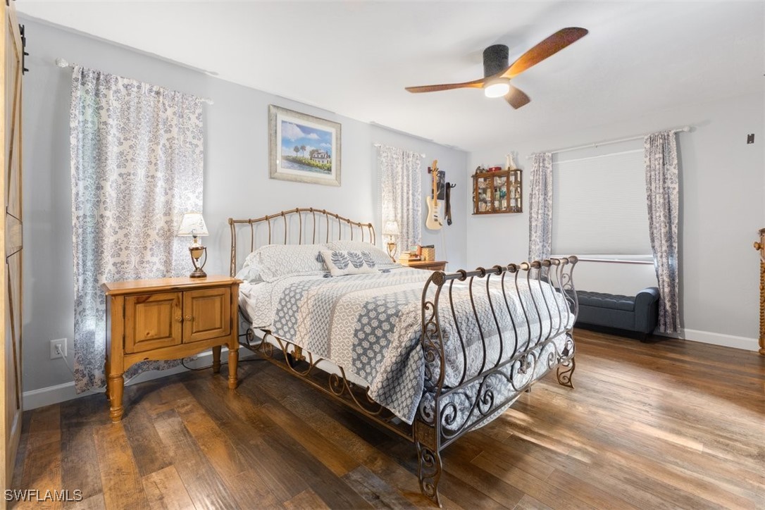 17321 Oak Creek Road Alva, FL 33920 - Photo 24 of 34 a spacious bedroom with a bed and a chandelier