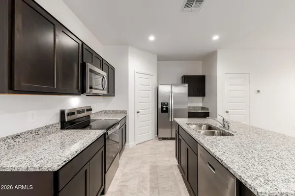 a kitchen with granite countertop kitchen island cabinets stainless steel appliances and a sink