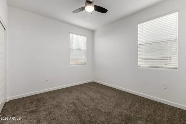 an empty room with closet and windows