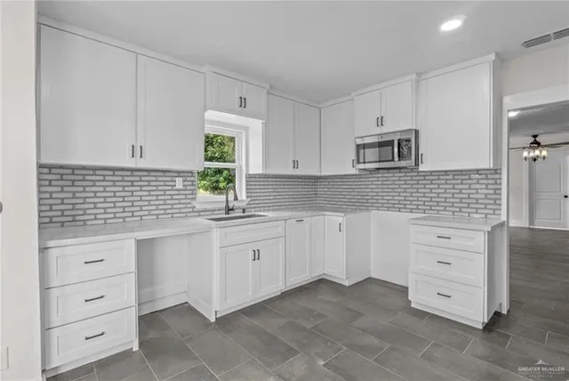 a kitchen with cabinets appliances a sink and a window