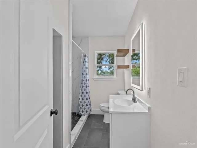 a bathroom with a sink toilet and shower