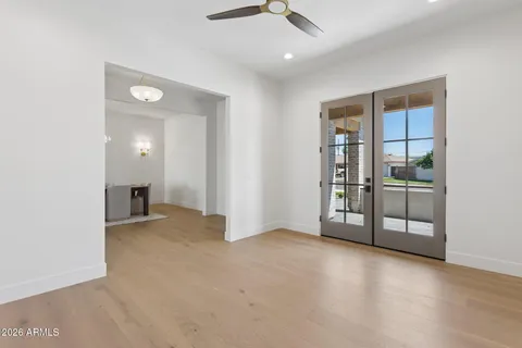 an empty room with windows and view of kitchen