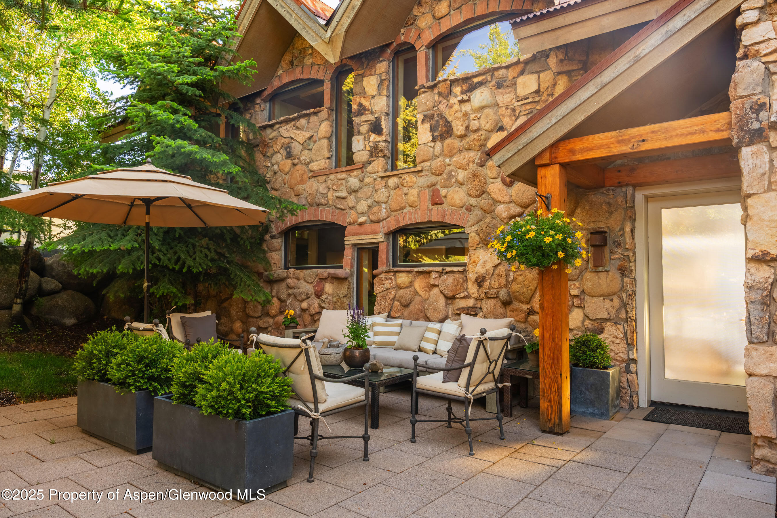 26 Bunker Loop Aspen, CO 81612 - Photo 12 of 103 a view of a patio with a table and chairs under an umbrella