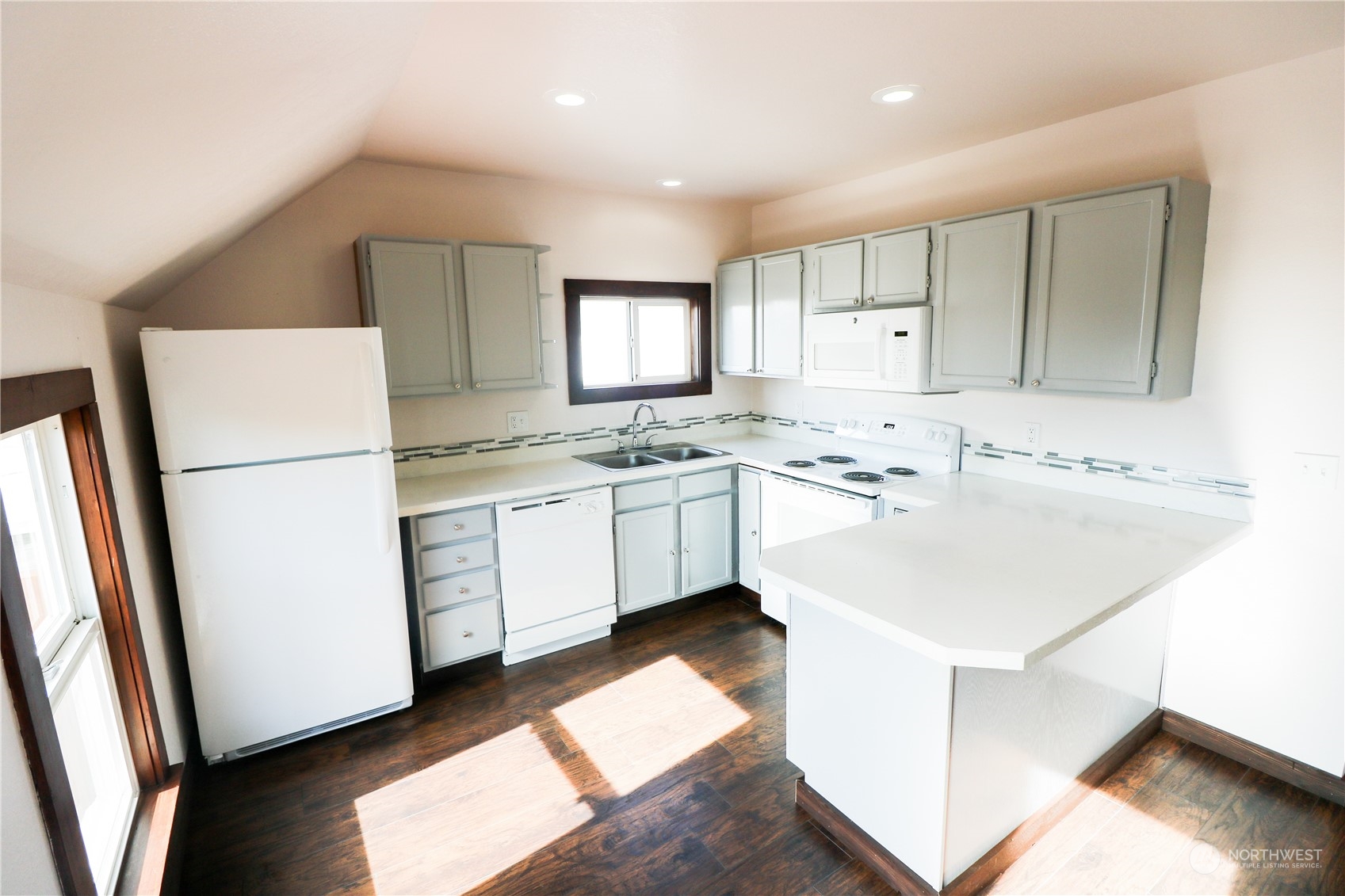 107 South M Street Aberdeen, WA 98520 - Photo 17 of 24 a kitchen with a sink a stove a refrigerator and white cabinets