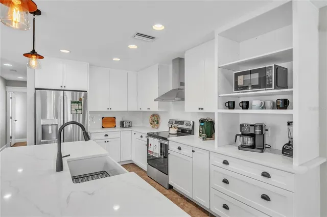 a kitchen with stainless steel appliances a sink a stove a refrigerator and cabinets