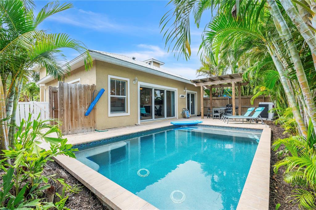 302 67th Street Holmes Beach, FL 34217 - Photo 2 of 38 a swimming pool with outdoor seating and yard