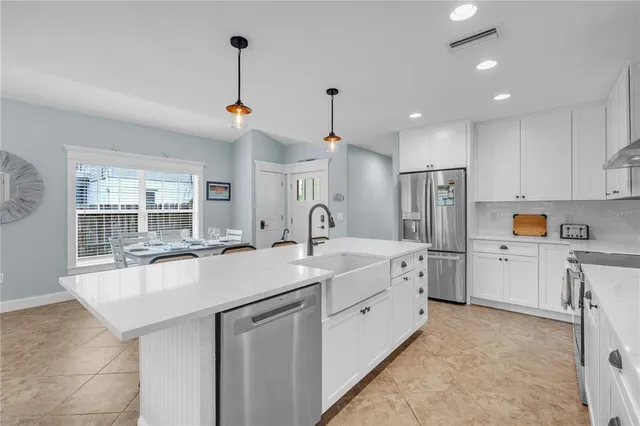 a kitchen with white cabinets and refrigerator