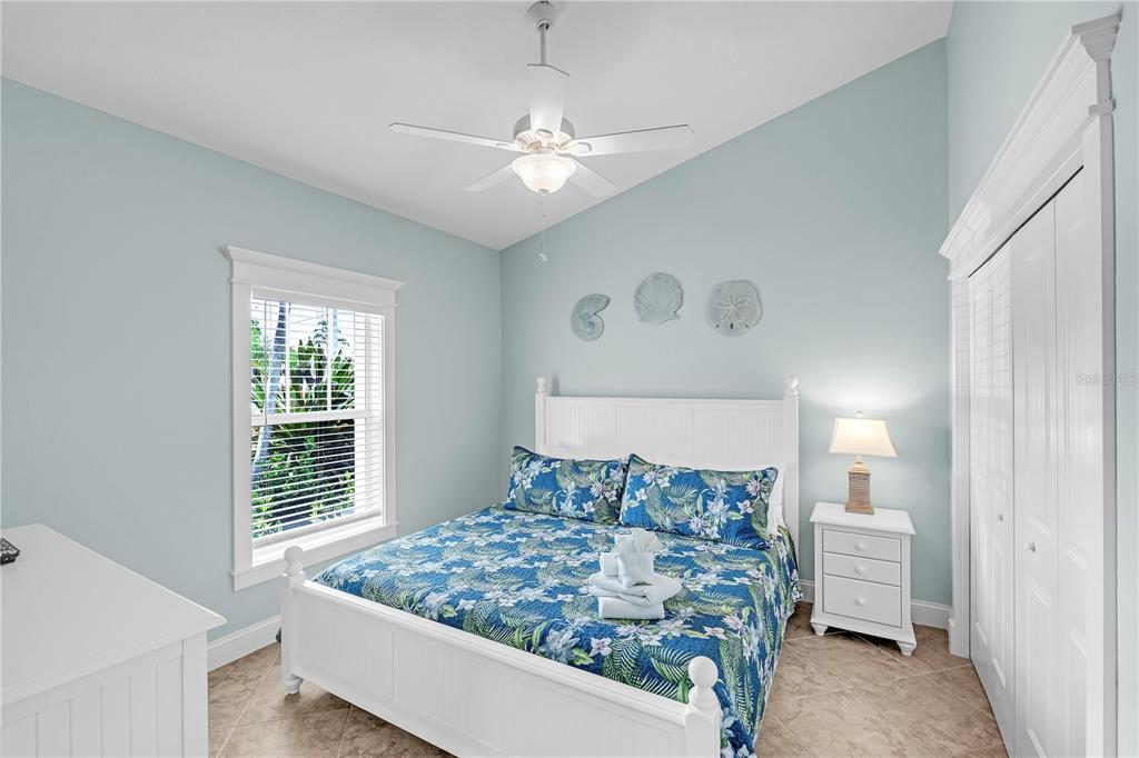 302 67th Street Holmes Beach, FL 34217 - Photo 23 of 38 a bedroom with a large bed and a chandelier