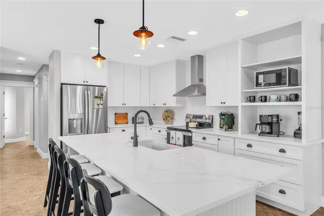 a kitchen with stainless steel appliances a table chairs and a refrigerator