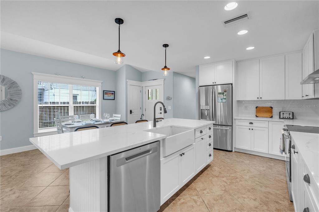 302 67th Street Holmes Beach, FL 34217 - Photo 8 of 38 a kitchen with white cabinets and refrigerator
