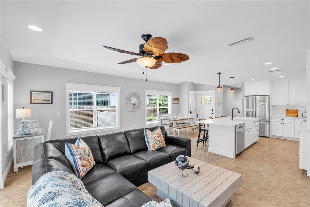 302 67th Street Holmes Beach, FL 34217 - Photo 9 of 38 a living room with kitchen island furniture and a chandelier