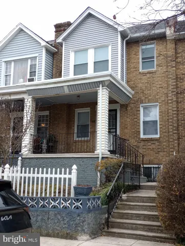 a view of a house with a small yard and wooden floor and fence