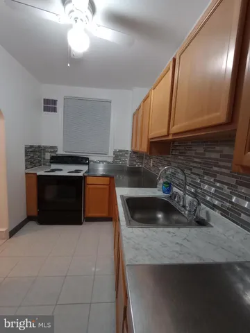 a kitchen with granite countertop a sink a stove and cabinets