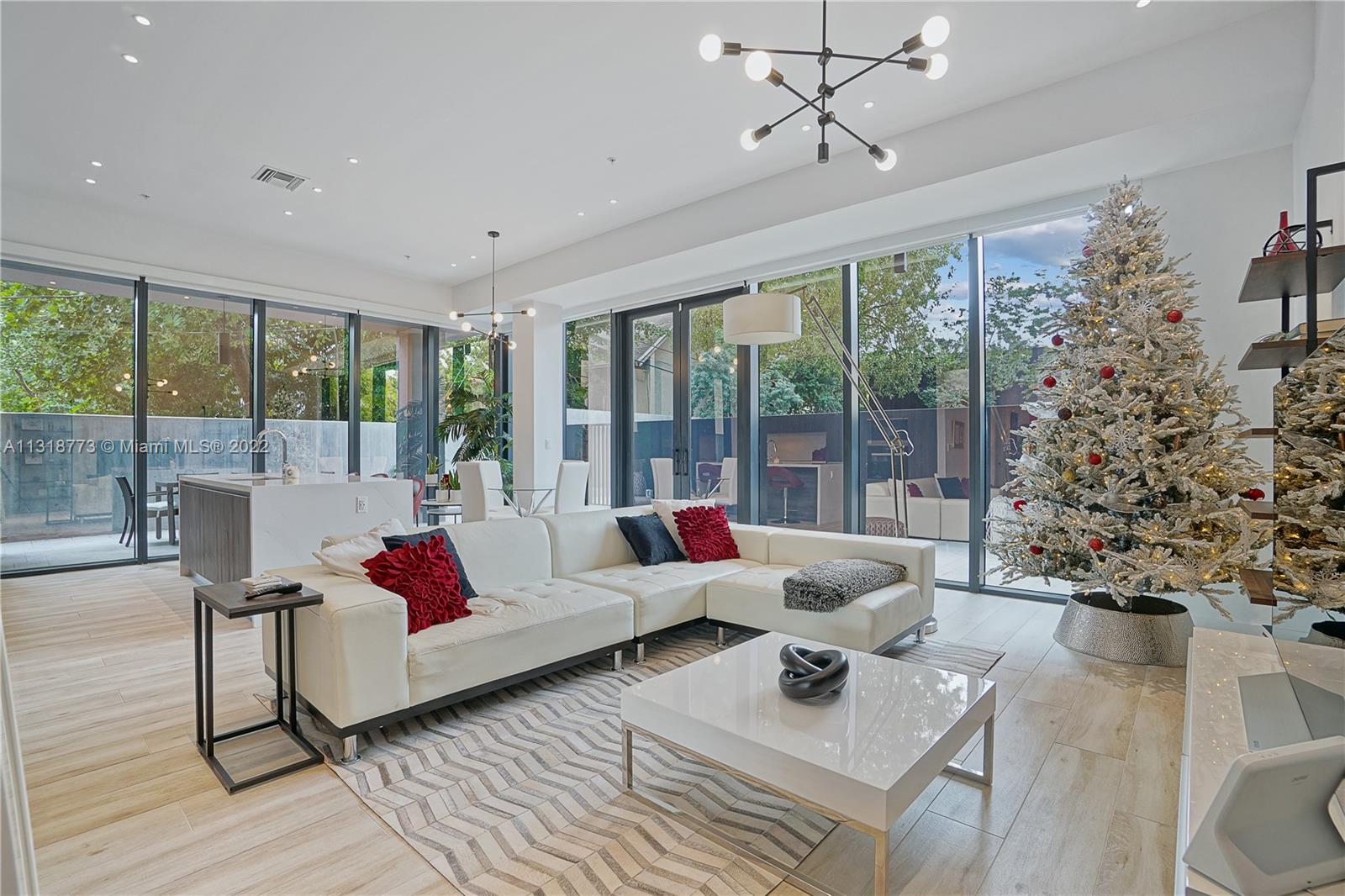 a living room with furniture and floor to ceiling windows