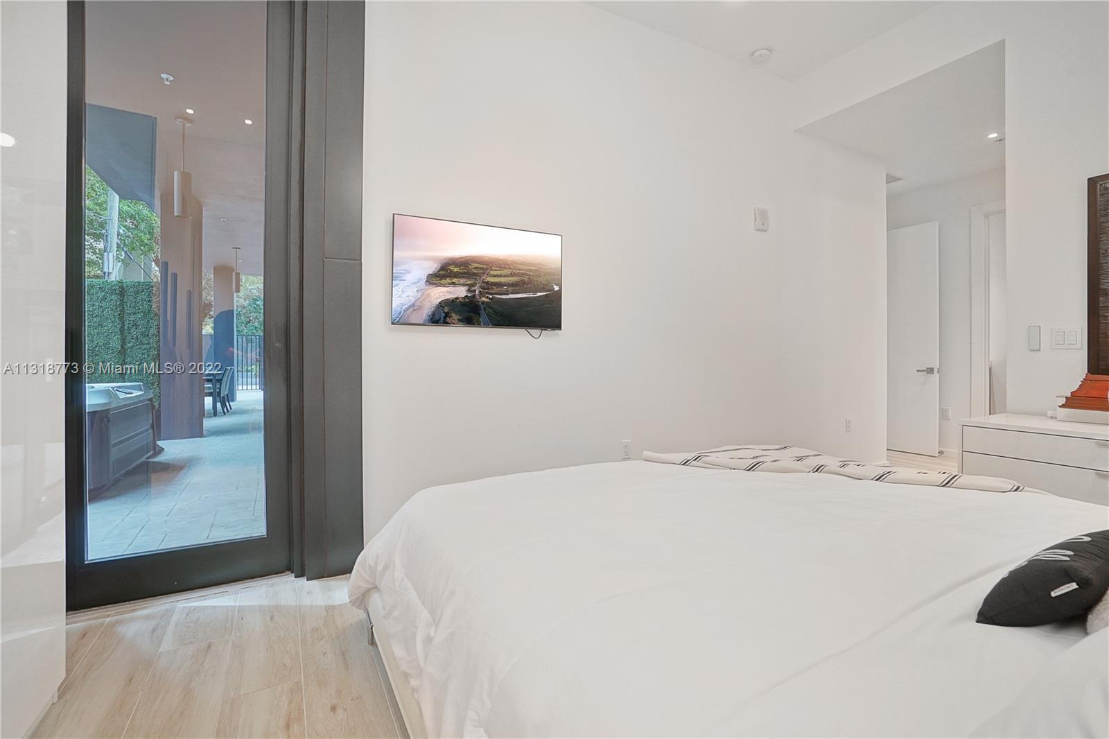 3156 Southwest 27th Avenue, Unit 101 Miami, FL 33133 - Photo 17 of 29 a bedroom with a bed and a painting on the wall