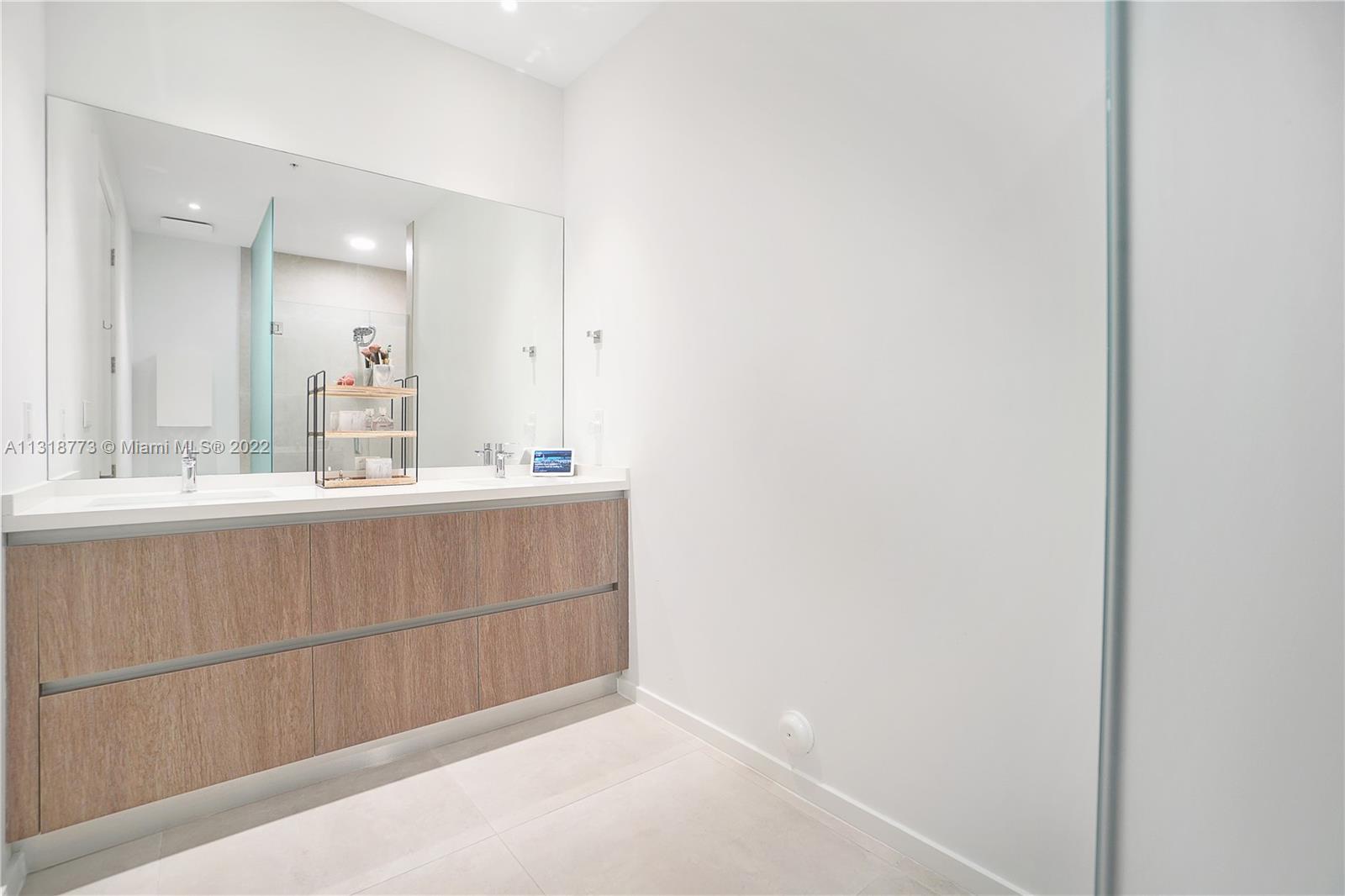 3156 Southwest 27th Avenue, Unit 101 Miami, FL 33133 - Photo 19 of 29 a bathroom with a sink and a mirror