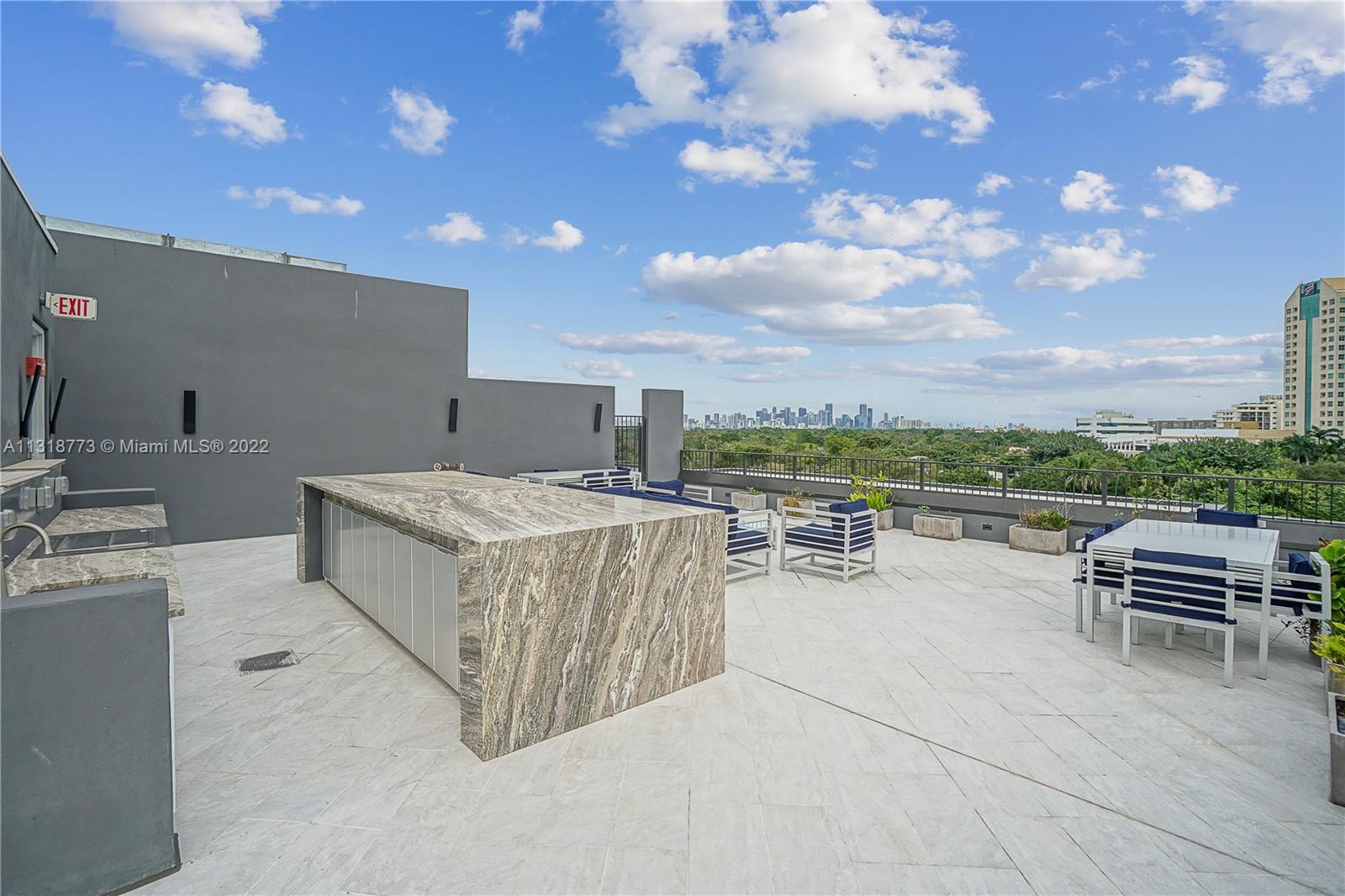 3156 Southwest 27th Avenue, Unit 101 Miami, FL 33133 - Photo 25 of 29 a view of a terrace with furniture and garden