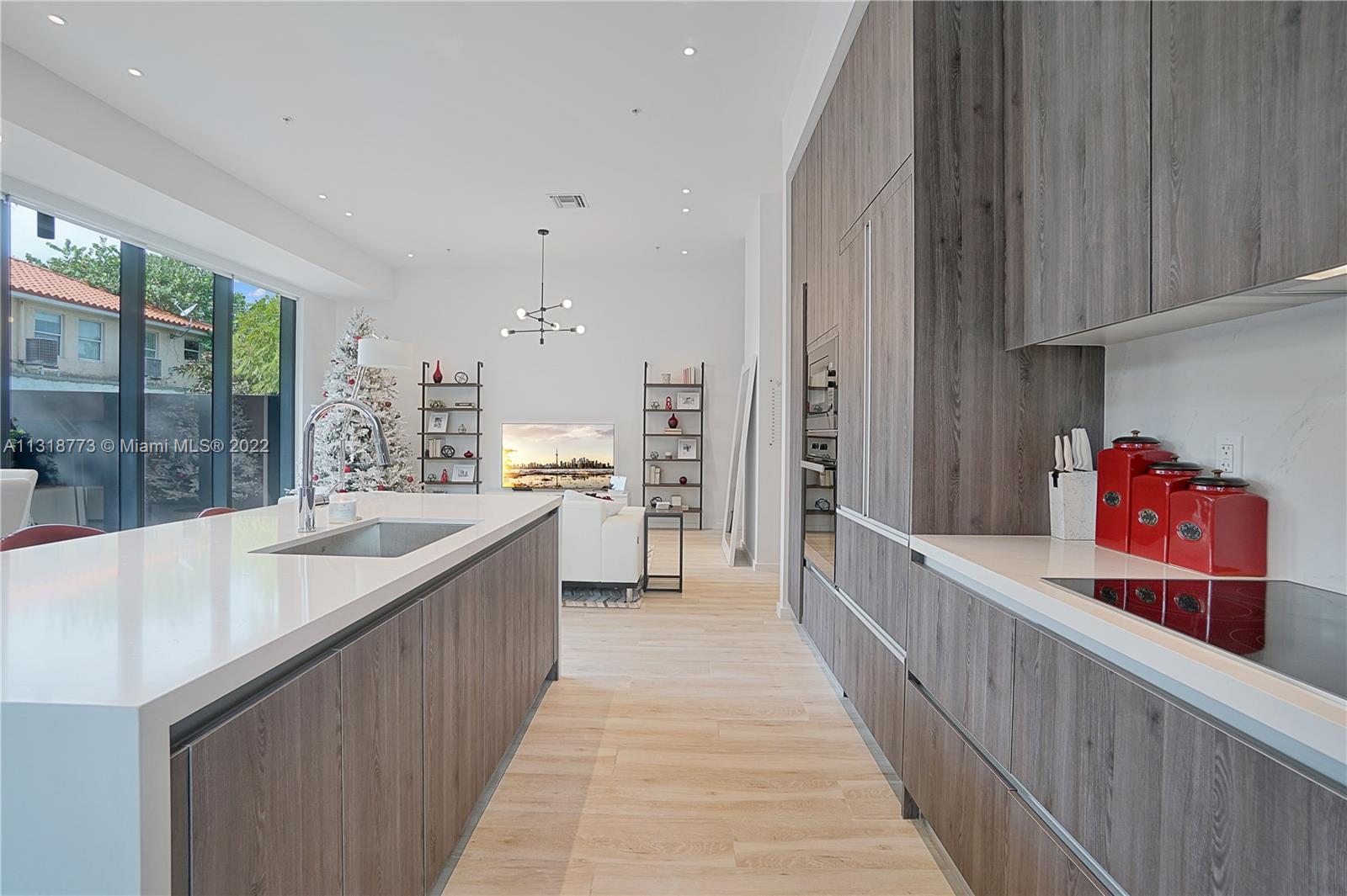 3156 Southwest 27th Avenue, Unit 101 Miami, FL 33133 - Photo 5 of 29 a large kitchen with stainless steel appliances a sink and cabinets