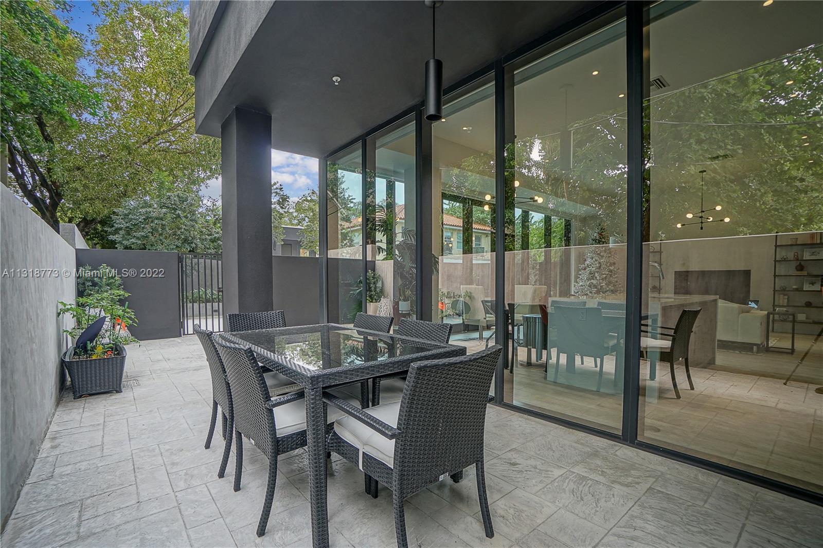 3156 Southwest 27th Avenue, Unit 101 Miami, FL 33133 - Photo 9 of 29 a view of a dining table and chairs in the patio