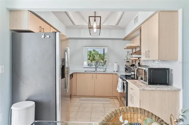 a kitchen with stainless steel appliances a refrigerator sink and microwave