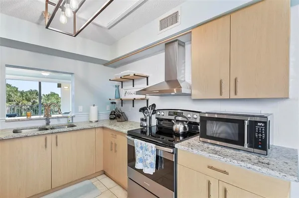 a kitchen with stainless steel appliances granite countertop a stove a sink and a microwave
