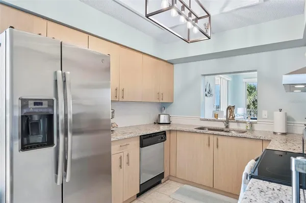 a kitchen with a sink a refrigerator and cabinets
