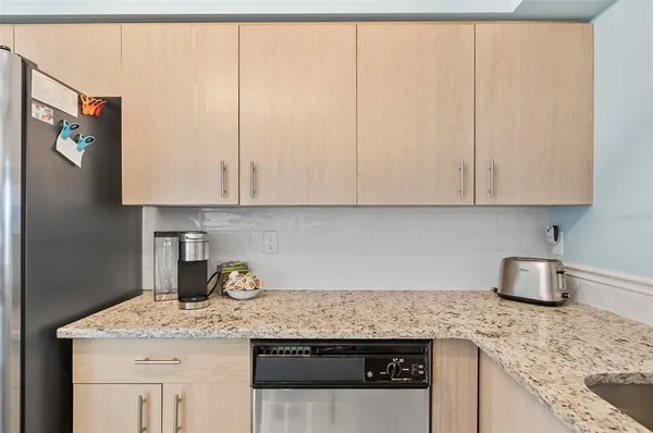 a kitchen with granite countertop a sink a stove and cabinets