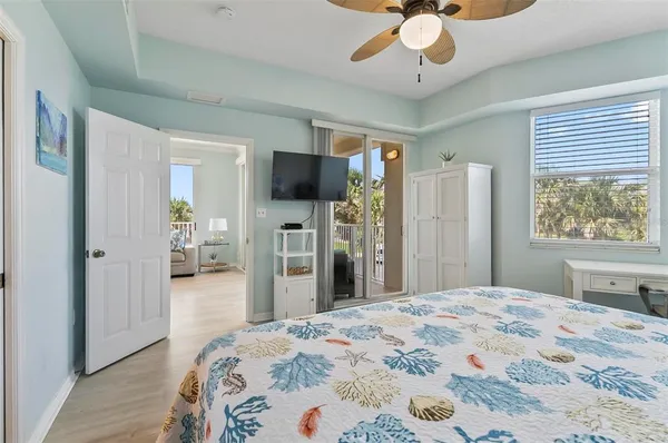 a bedroom with a bed and a flat tv screen on dresser