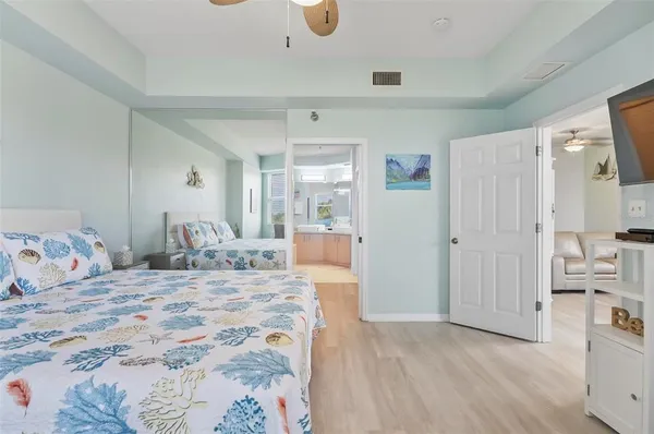 a bedroom with a large bed and a wooden floor