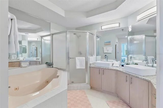 a bathroom with a tub a sink a mirror a shower and vanity