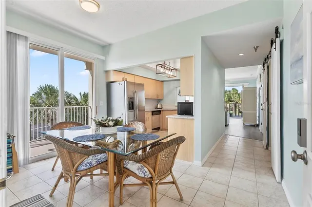 a dining room with furniture and large windows