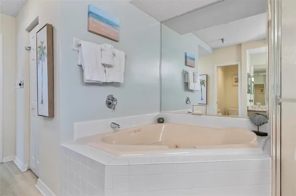 a bathroom with a tub sink and mirror