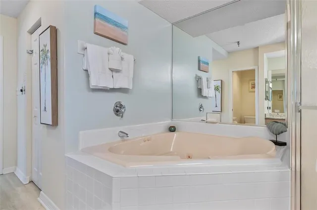 a bathroom with a tub sink and mirror