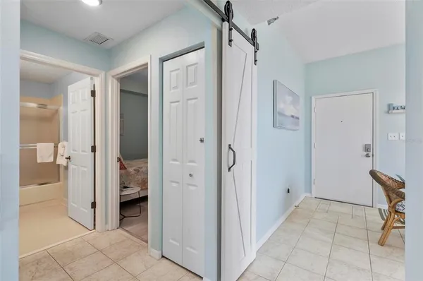 a view of a hallway with bathroom and a shower
