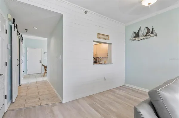a view of a livingroom with wooden floor and a bathroom