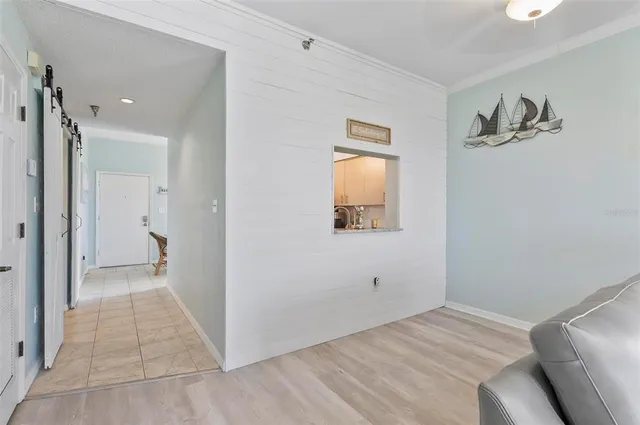 a view of a livingroom with wooden floor and a bathroom