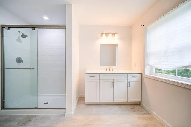 a bathroom with a sink a mirror and a shower